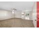 Spacious carpeted living room with a ceiling fan and view to the kitchen at 1039 Beulah Dr, Edgewater, FL 32132