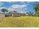 Large backyard with grass, mature trees, and a wooden fence at 1043 Beulah Dr, Edgewater, FL 32132