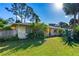 Landscaped front yard with vibrant green grass, palm trees and a glimpse of the home's facade at 1043 Beulah Dr, Edgewater, FL 32132