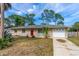 Charming single-story home with a well-maintained front yard, red front door and attached garage at 1043 Beulah Dr, Edgewater, FL 32132