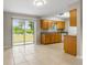 Bright kitchen with oak cabinets, tile flooring, and a sliding door providing a seamless transition to the backyard at 1043 Beulah Dr, Edgewater, FL 32132