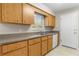 Well-lit kitchen features oak cabinets, tile flooring, and ample counter space for food preparation at 1043 Beulah Dr, Edgewater, FL 32132