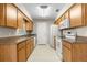 Functional kitchen with oak cabinets, white appliances, and tile flooring for easy maintenance at 1043 Beulah Dr, Edgewater, FL 32132