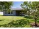 Home backyard features lush lawn, modern exterior and mature trees at 1100 Loch Linnhe Ct, New Smyrna Beach, FL 32168