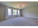 Large bedroom featuring a large window, a modern light fixture, and plush carpet at 1100 Loch Linnhe Ct, New Smyrna Beach, FL 32168