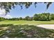 Expansive green golf course with mature trees and a sand trap, perfect for a relaxing round of golf at 1100 Loch Linnhe Ct, New Smyrna Beach, FL 32168