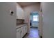 Hallway with built-in storage and granite countertops leads to a well-lit laundry room at 1100 Loch Linnhe Ct, New Smyrna Beach, FL 32168