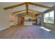 Bright living area with wood-look tile, vaulted beamed ceiling, a bar area, and a kitchen with modern appliances at 1100 Loch Linnhe Ct, New Smyrna Beach, FL 32168