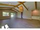 Living room featuring wood-look floors, vaulted ceiling with beams, a bar area and sliding glass doors at 1100 Loch Linnhe Ct, New Smyrna Beach, FL 32168