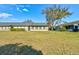 View of the lush backyard and lanai, perfect for outdoor living and relaxation at 1140 Fairvilla Dr, New Smyrna Beach, FL 32168