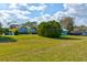 Spacious lawn with mature trees surrounding single story homes in the distance at 1140 Fairvilla Dr, New Smyrna Beach, FL 32168