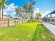 A spacious fenced backyard features a lush lawn and mature trees, perfect for outdoor activities and relaxation at 1175 Margina Ave, Daytona Beach, FL 32114