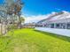 Expansive grass backyard features a screened-in pool area and a wood fence at 1175 Margina Ave, Daytona Beach, FL 32114