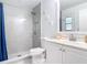 Bathroom featuring a tiled shower with rainfall showerhead, updated fixtures, and white vanity at 1175 Margina Ave, Daytona Beach, FL 32114