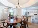 Formal dining room with wood table and decorative chandelier open to living room and kitchen at 1175 Margina Ave, Daytona Beach, FL 32114