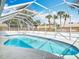 A screened-in pool with blue tile and a surrounding patio complements the home's outdoor living space at 1175 Margina Ave, Daytona Beach, FL 32114