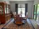 Inviting dining room with wood table, 6 chairs, decorative rug, china cabinet, and sliding glass doors at 123 Old Mill Pond Rd, Edgewater, FL 32141