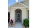 Inviting entryway with arched entrance and a storm door, complemented by attractive landscaping and stone accents at 123 Old Mill Pond Rd, Edgewater, FL 32141