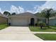 Beautiful single-story home with a two-car garage, inviting entrance, and a lush green lawn with a palm tree at 123 Old Mill Pond Rd, Edgewater, FL 32141