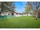 Well-manicured backyard featuring a storage shed and mature shade trees at 1240 Wayne Ave, New Smyrna Beach, FL 32168