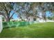 Expansive backyard with green picket fencing and mature trees providing plenty of shade at 1240 Wayne Ave, New Smyrna Beach, FL 32168