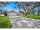 Inviting home with a long, wide driveway, two-car garage, and mature landscaping at 1240 Wayne Ave, New Smyrna Beach, FL 32168