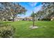 Well-manicured front yard with mature trees and landscaping at 1240 Wayne Ave, New Smyrna Beach, FL 32168