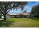 Charming single-story home with a well-manicured lawn and mature trees providing shade at 1240 Wayne Ave, New Smyrna Beach, FL 32168