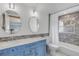 Bright bathroom with double sinks, elegant blue vanity, and tiled shower at 128 Dixwood Ave, Edgewater, FL 32132