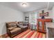 Cozy bedroom with comfortable seating, a red accent cabinet, and a unique striped rug at 128 Dixwood Ave, Edgewater, FL 32132