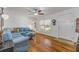 Bright living room with hardwood floors, blue sofa, ceiling fan, and front entrance view at 128 Dixwood Ave, Edgewater, FL 32132