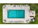 Aerial view of community pool with lounge chairs, tables, and lush green surroundings at 144 S Halifax Ave # 26, Daytona Beach, FL 32118