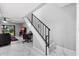 Modern staircase with black metal railings leading to the upper level with sleek marble floors at 144 S Halifax Ave # 26, Daytona Beach, FL 32118