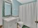 This bathroom features a modern sink vanity, large mirror, updated fixtures and tub-shower at 1462 General Mcarthur Ave, Daytona Beach, FL 32124