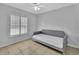 This bedroom is bathed in natural light, featuring tile flooring, a ceiling fan, and a comfortable daybed at 1462 General Mcarthur Ave, Daytona Beach, FL 32124