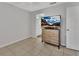 Cozy bedroom features a modern dresser with TV, tile floors, and a view to an ensuite bathroom at 1462 General Mcarthur Ave, Daytona Beach, FL 32124