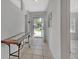 Bright entryway with neutral walls, tile floors, a decorative table and a front door with a light blue trim at 1462 General Mcarthur Ave, Daytona Beach, FL 32124