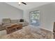 Cozy living room featuring tile flooring, a comfortable couch, coffee table and sliding door to the outside at 1462 General Mcarthur Ave, Daytona Beach, FL 32124