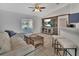 Cozy living room featuring tile flooring, a comfortable couch, ceiling fan, and sliding door to the outside at 1462 General Mcarthur Ave, Daytona Beach, FL 32124