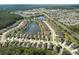 An aerial view of homes nestled near a green wooded area with a pond with a water feature in the distance at 1502 Areca Palm Dr, Port Orange, FL 32128