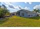 Exterior view of the home, highlighting the well-maintained lawn, landscaping, and screened-in patio at 1502 Areca Palm Dr, Port Orange, FL 32128