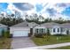 Overhead shot of a charming single-Gathering home, showcasing landscaping, a two-car garage, shutters, and a paved driveway at 1731 Red Rock Rd, New Smyrna Beach, FL 32168