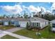 Aerial of attractive one-story home with a two-car garage, shutters, and a landscaped front yard at 1731 Red Rock Rd, New Smyrna Beach, FL 32168