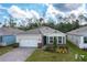 Aerial view of a well-maintained home with landscaping, a two-car garage, shutters, and brick accents at 1731 Red Rock Rd, New Smyrna Beach, FL 32168