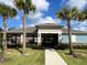 Community clubhouse with palm trees, and a manicured lawn provides inviting entrance at 1731 Red Rock Rd, New Smyrna Beach, FL 32168