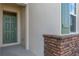 Close-up featuring a front entrance with green front door, stone brickwork, and siding at 1731 Red Rock Rd, New Smyrna Beach, FL 32168