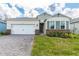 Charming one-story home featuring a two-car garage, brick accents, shutters, and a well-manicured lawn at 1731 Red Rock Rd, New Smyrna Beach, FL 32168