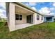 Covered patio with sliding glass doors and a view of the expansive green lawn at 1731 Red Rock Rd, New Smyrna Beach, FL 32168