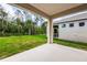 Covered patio provides shaded outdoor space and a view of the backyard and trees at 1731 Red Rock Rd, New Smyrna Beach, FL 32168