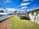 Landscaped backyard with green lawn, partial fence, and enclosed patio under a sunny sky at 18 Silk Oaks Dr, Ormond Beach, FL 32176